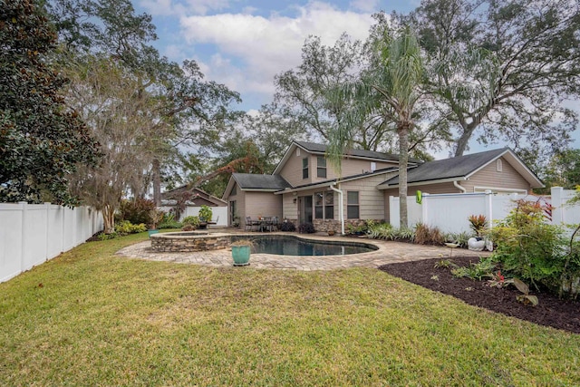 back of property featuring a lawn, a patio area, and a pool with hot tub