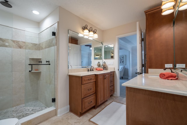 bathroom with an enclosed shower, vanity, and tile patterned floors