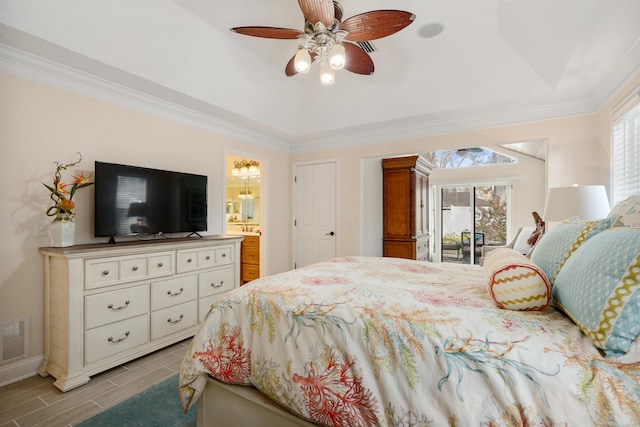 bedroom with multiple windows, a raised ceiling, ornamental molding, and access to outside