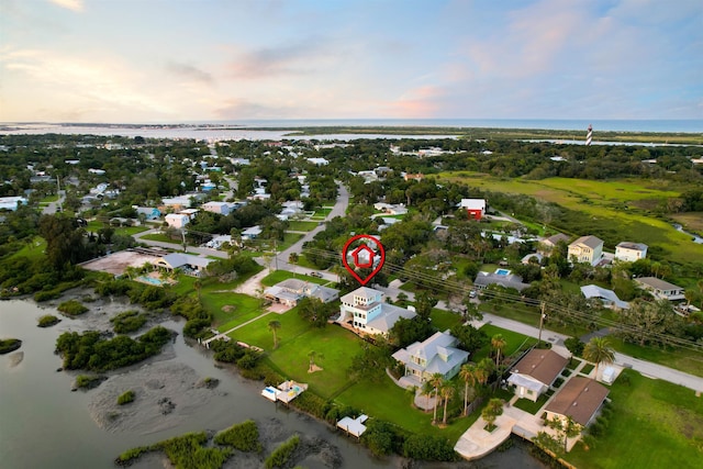 aerial view at dusk featuring a water view