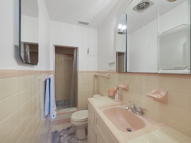 bathroom featuring a shower with curtain, vanity, toilet, and tile walls