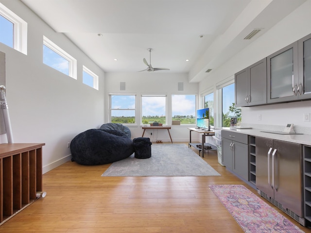 interior space with ceiling fan, gray cabinets, and light hardwood / wood-style flooring