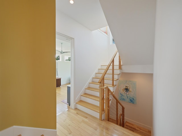 staircase with ceiling fan and hardwood / wood-style flooring