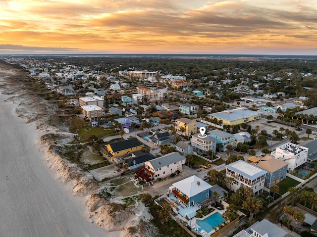 aerial view at dusk with a view of the beach and a water view