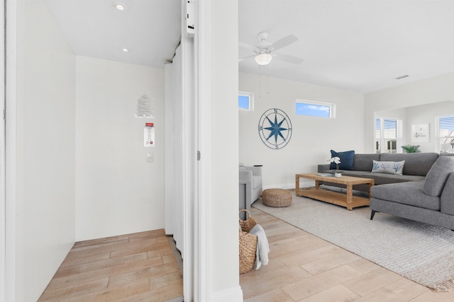 living room featuring ceiling fan and light hardwood / wood-style floors