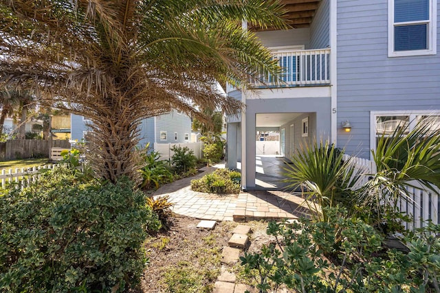 view of exterior entry featuring a patio and a balcony