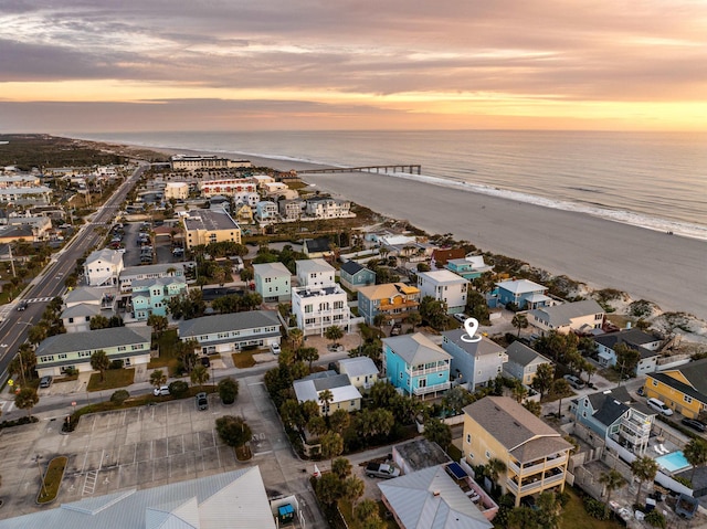 aerial view at dusk featuring a water view