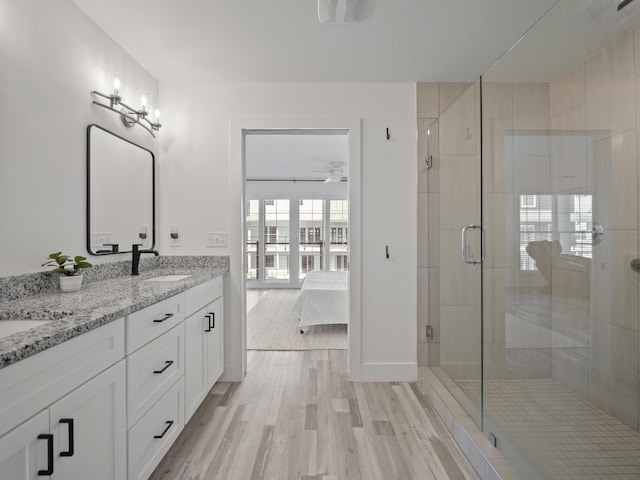 bathroom with ceiling fan, walk in shower, vanity, and wood-type flooring