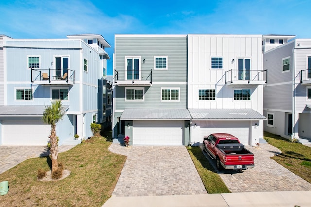 view of front of property featuring a balcony, a garage, and a front lawn