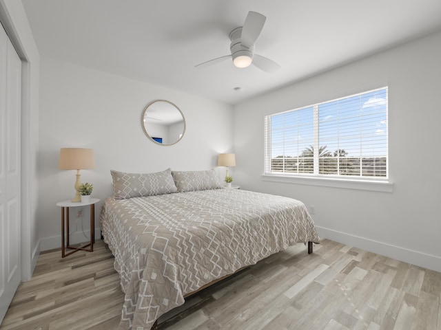 bedroom featuring ceiling fan, light hardwood / wood-style floors, and a closet