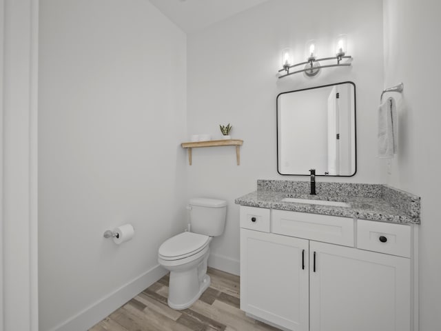 bathroom with toilet, wood-type flooring, and vanity