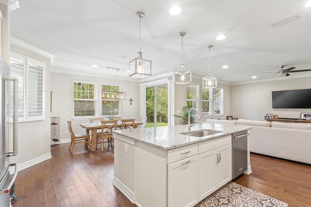 kitchen with sink, white cabinetry, hanging light fixtures, a kitchen island with sink, and ornamental molding