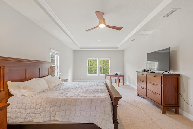 bedroom featuring a raised ceiling, ceiling fan, light carpet, and a textured ceiling