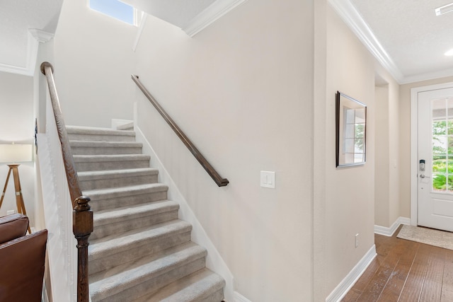 staircase featuring hardwood / wood-style floors and ornamental molding