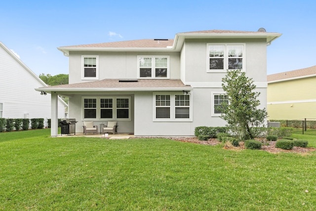 back of house featuring a lawn and a patio area