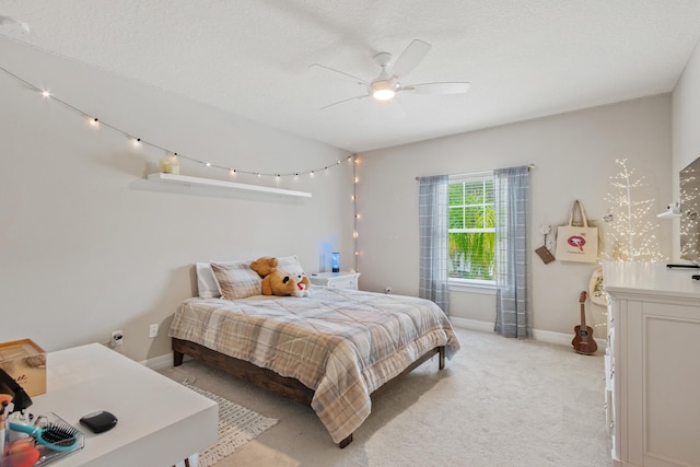 bedroom with ceiling fan, light colored carpet, and a textured ceiling