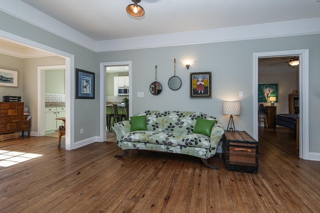 living room with dark wood-type flooring and ornamental molding