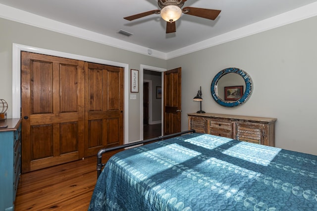 bedroom featuring hardwood / wood-style flooring, ornamental molding, a closet, and ceiling fan