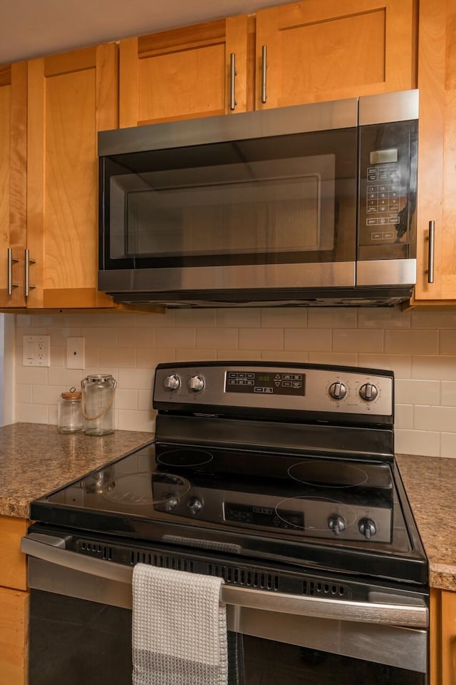 kitchen featuring stainless steel appliances, decorative backsplash, and stone counters