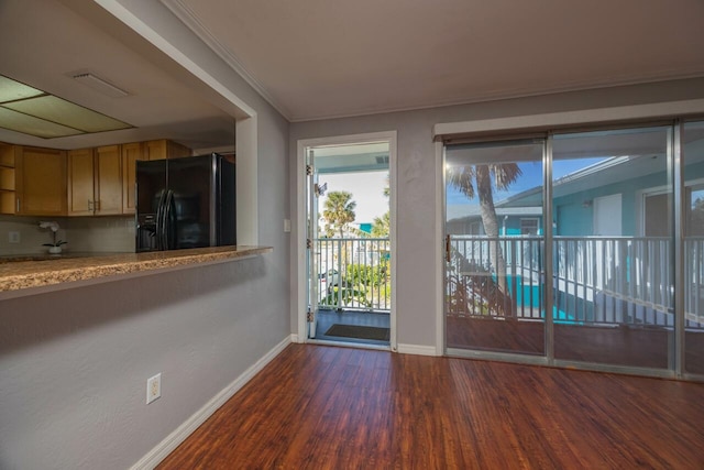 doorway to outside featuring dark hardwood / wood-style flooring and ornamental molding