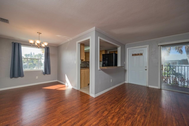 unfurnished living room with dark wood-type flooring, crown molding, a chandelier, and a textured ceiling