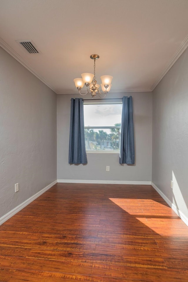 empty room with crown molding, dark hardwood / wood-style floors, and a chandelier