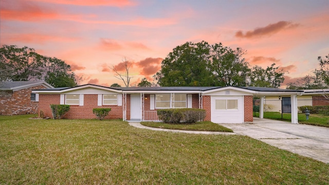 ranch-style home with a lawn and a carport