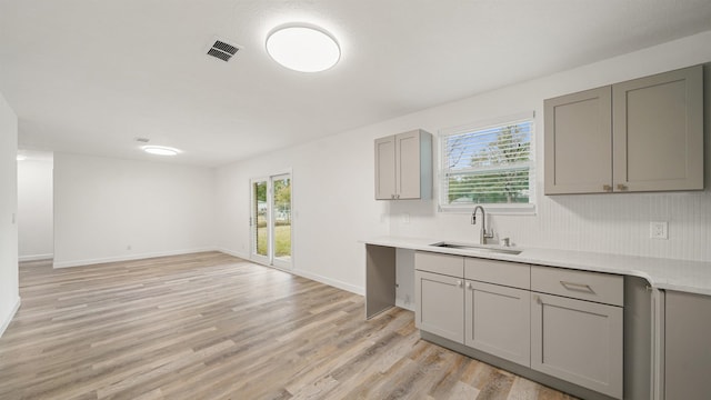 kitchen featuring gray cabinetry, plenty of natural light, light wood-type flooring, and sink