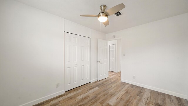 unfurnished bedroom featuring ceiling fan, light hardwood / wood-style flooring, and a closet