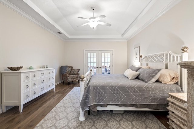 bedroom with a tray ceiling, french doors, visible vents, ornamental molding, and wood finished floors