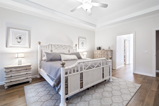 bedroom featuring a ceiling fan, ornamental molding, baseboards, and hardwood / wood-style flooring