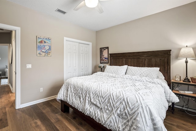 bedroom with a ceiling fan, visible vents, baseboards, a closet, and dark wood-style floors