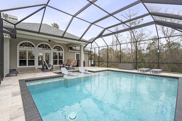 outdoor pool with a lanai, a ceiling fan, french doors, and a patio