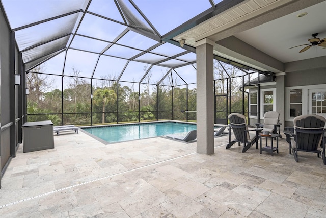 pool featuring a patio area, glass enclosure, and a ceiling fan