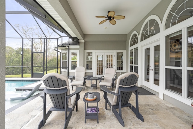 exterior space featuring a lanai, ceiling fan, an outdoor pool, and french doors