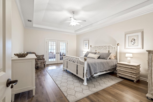 bedroom featuring french doors, a raised ceiling, visible vents, ornamental molding, and hardwood / wood-style flooring