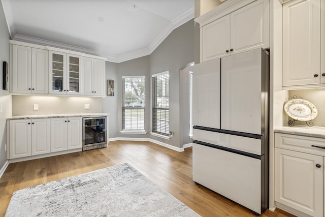 kitchen featuring ornamental molding, wine cooler, white cabinets, and refrigerator