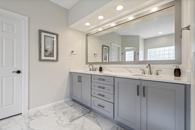 bathroom featuring double vanity, baseboards, marble finish floor, a sink, and recessed lighting