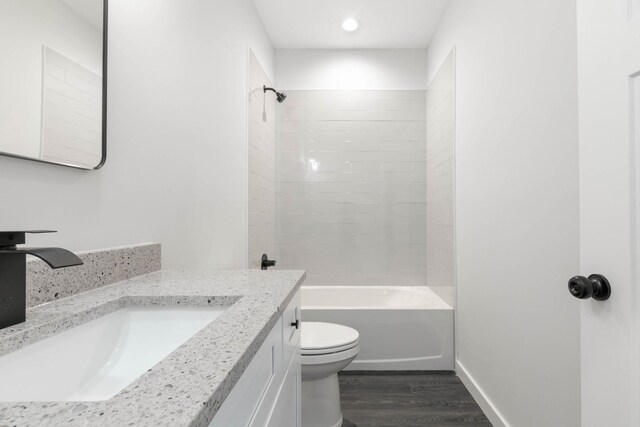 full bathroom featuring vanity, hardwood / wood-style flooring, toilet, and tiled shower / bath