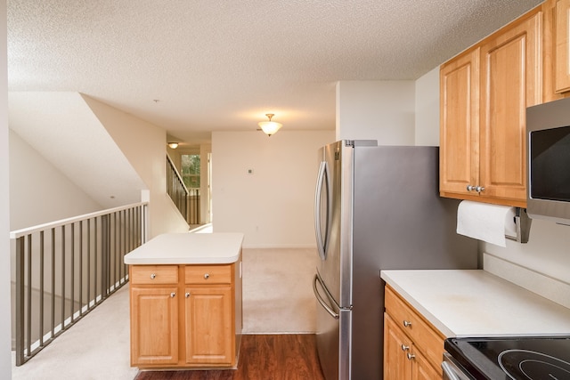 kitchen with appliances with stainless steel finishes, a textured ceiling, and dark hardwood / wood-style flooring