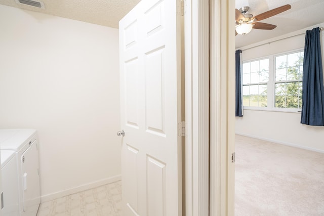 laundry room featuring light carpet, ceiling fan, a textured ceiling, and washing machine and clothes dryer