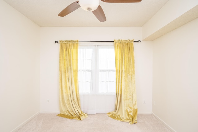 unfurnished room with ceiling fan and carpet flooring