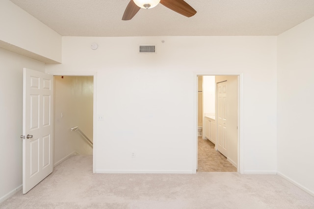 carpeted spare room featuring ceiling fan and a textured ceiling