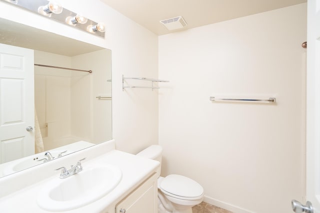 bathroom with vanity, a shower, and toilet