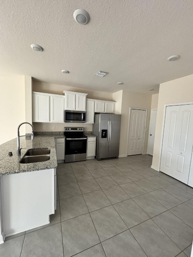 kitchen featuring light stone counters, sink, white cabinets, and appliances with stainless steel finishes