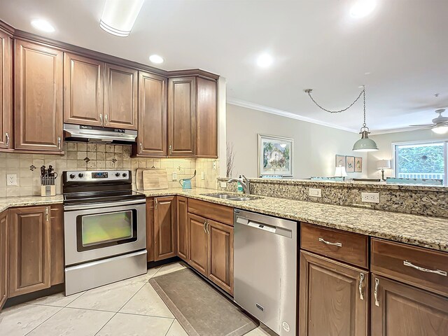 kitchen featuring light stone counters, sink, light tile patterned floors, and stainless steel appliances