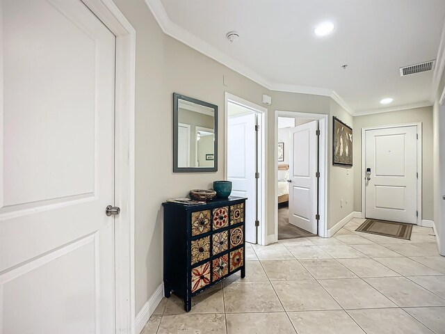 hall with crown molding and light tile patterned floors