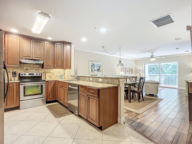 kitchen with kitchen peninsula, light stone counters, stainless steel appliances, ceiling fan, and sink