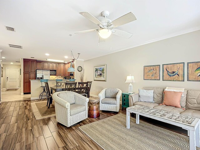 living room featuring ceiling fan and ornamental molding