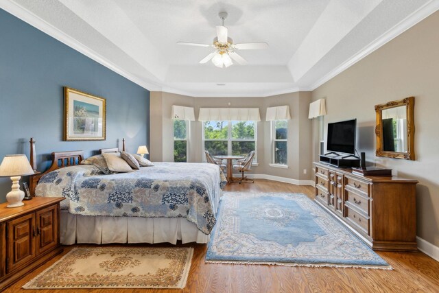 613 Wild Bird Ln, Saint Augustine, FL 32080 - bedroom featuring a tray ceiling, wood finished floors, baseboards, ceiling fan, and ornamental molding